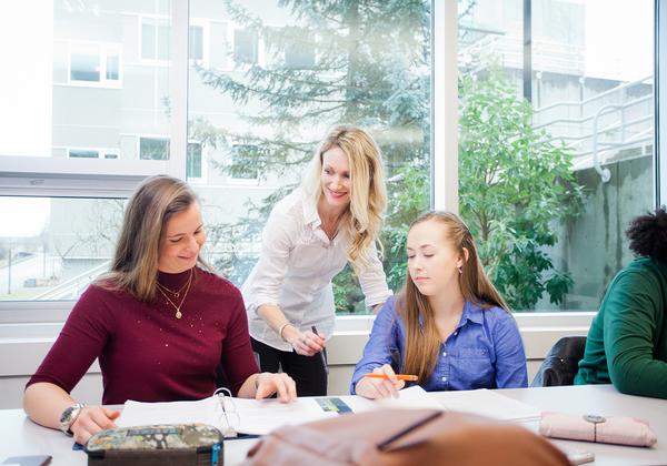 female instructor stands with two seated females