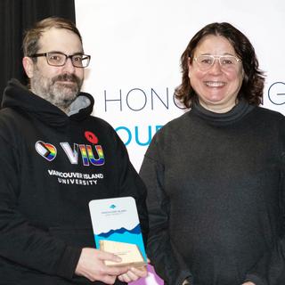 Chris Buechler receives the award for Service Excellence from VIU President Deb Saucier