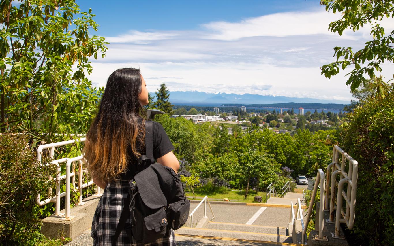 young woman enjoys view with her back to the camera